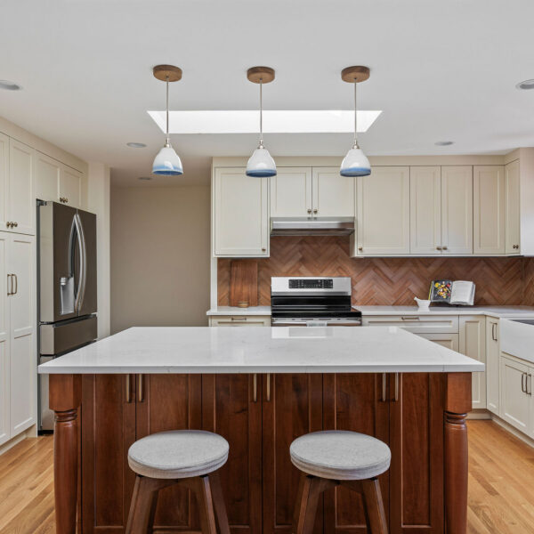 Matthews Beach kitchen with a wall of cream pantry cabinets, a stainless refrigerator, and a wood island