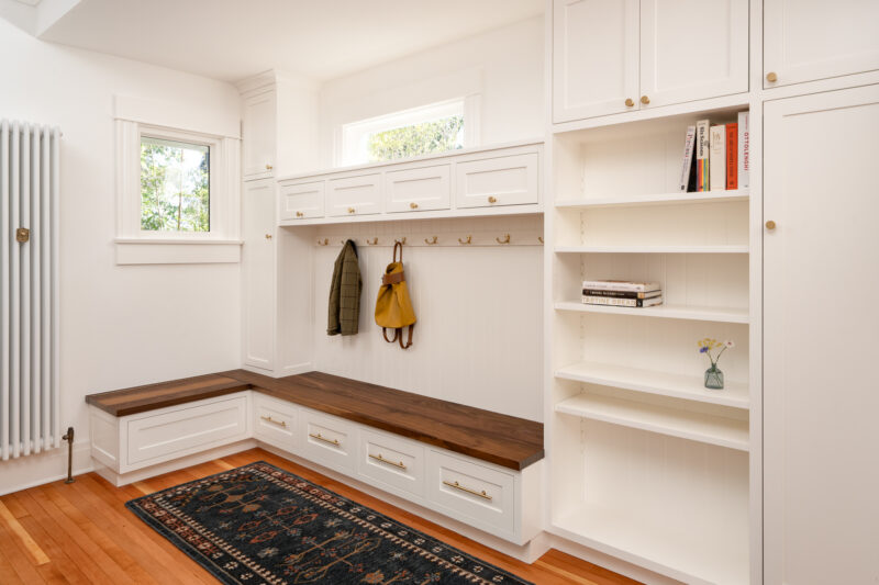 Capitol Hill mudroom with a built-in corner bench, coat hooks, and open shelving, created from part of the covered porch