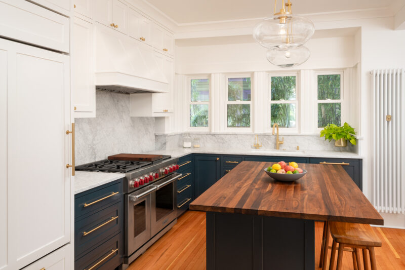 Capitol Hill kitchen with a paneled refrigerator, professional range, and walnut-topped island under glass pendant lights