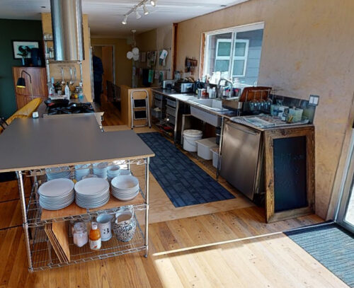 Before photo of the original North Beach kitchen with steel counters and open wire shelving