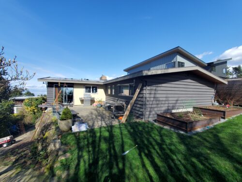 Before photo of the North Beach home exterior and lawn with Puget Sound beyond