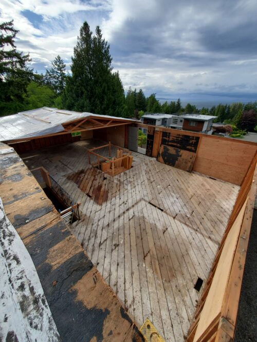 Construction photo of the North Beach upper deck stripped down to the subfloor with trees beyond