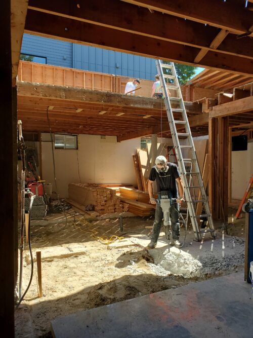 Construction photo of a crew member working in the North Beach lower level during structural work