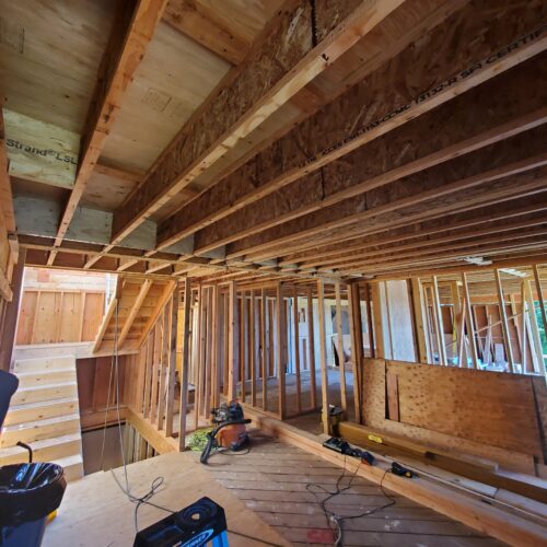Construction photo of framed interior walls and floor joists inside the North Beach addition