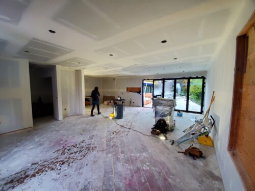 Construction photo of North Beach interior after drywall with a wall of new glass doors