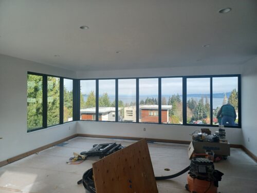 Construction photo of the North Beach primary suite with a wall of windows facing Puget Sound